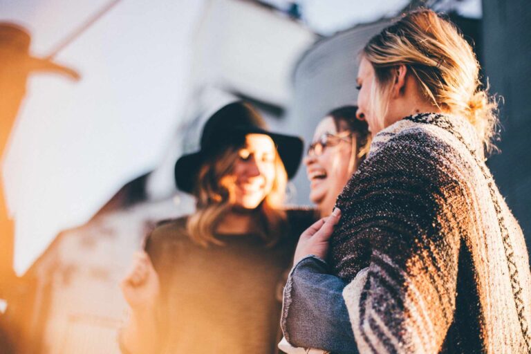Nell'immagine tre ragazze che sorridono e parlano
